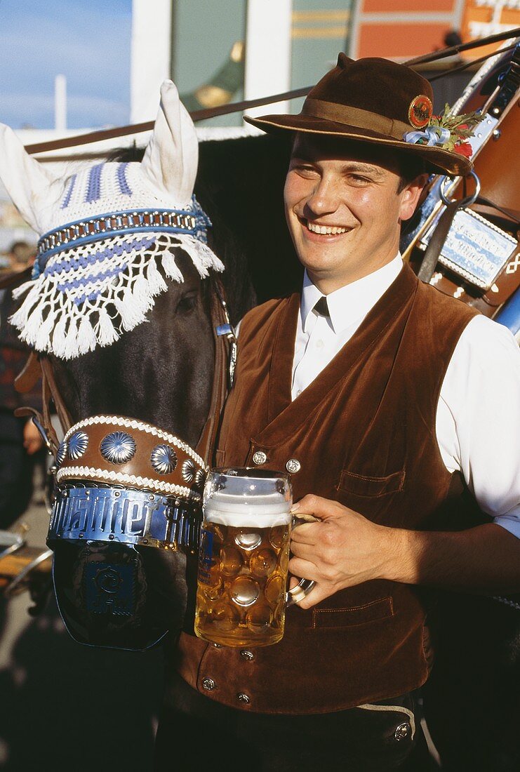 Coachman with tankard & decorated horse at Oktoberfest