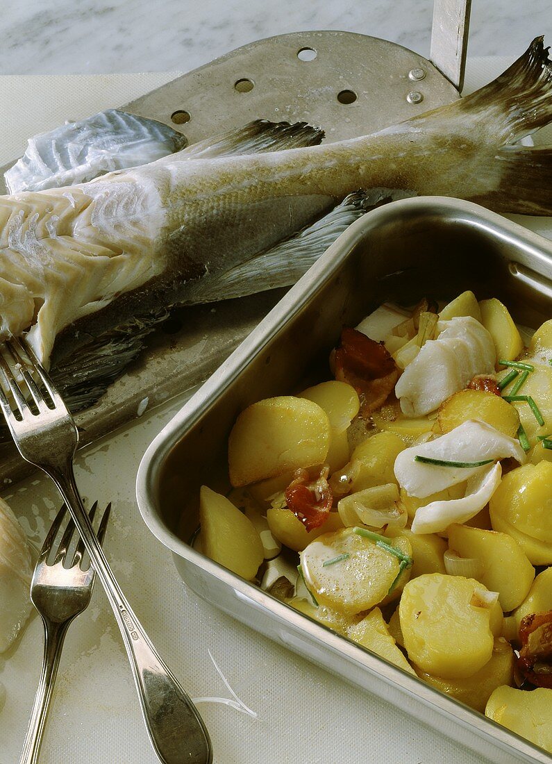 Pannfisch (fried fish) with potatoes in a roasting tin
