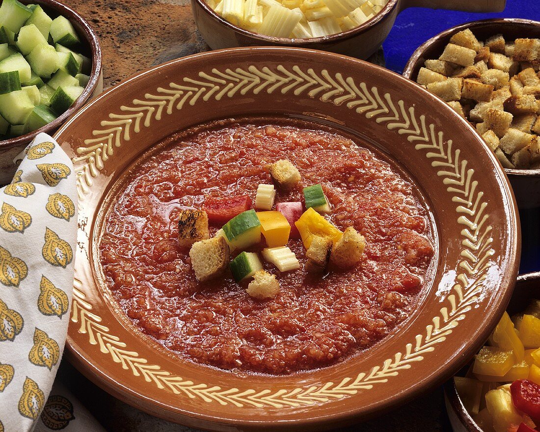 Gazpacho on ceramic plate with diced vegetables and croutons