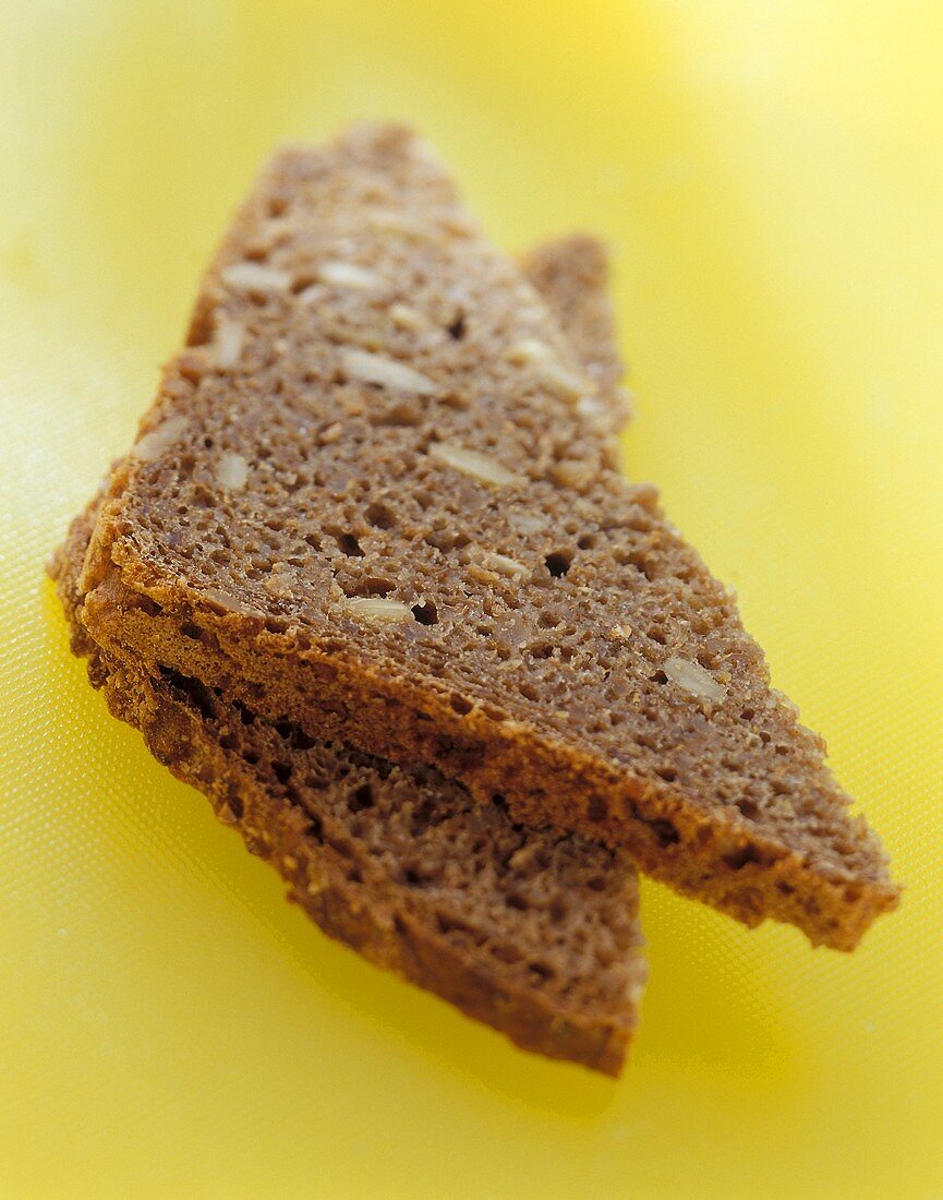 Two wholemeal bread triangles on yellow background