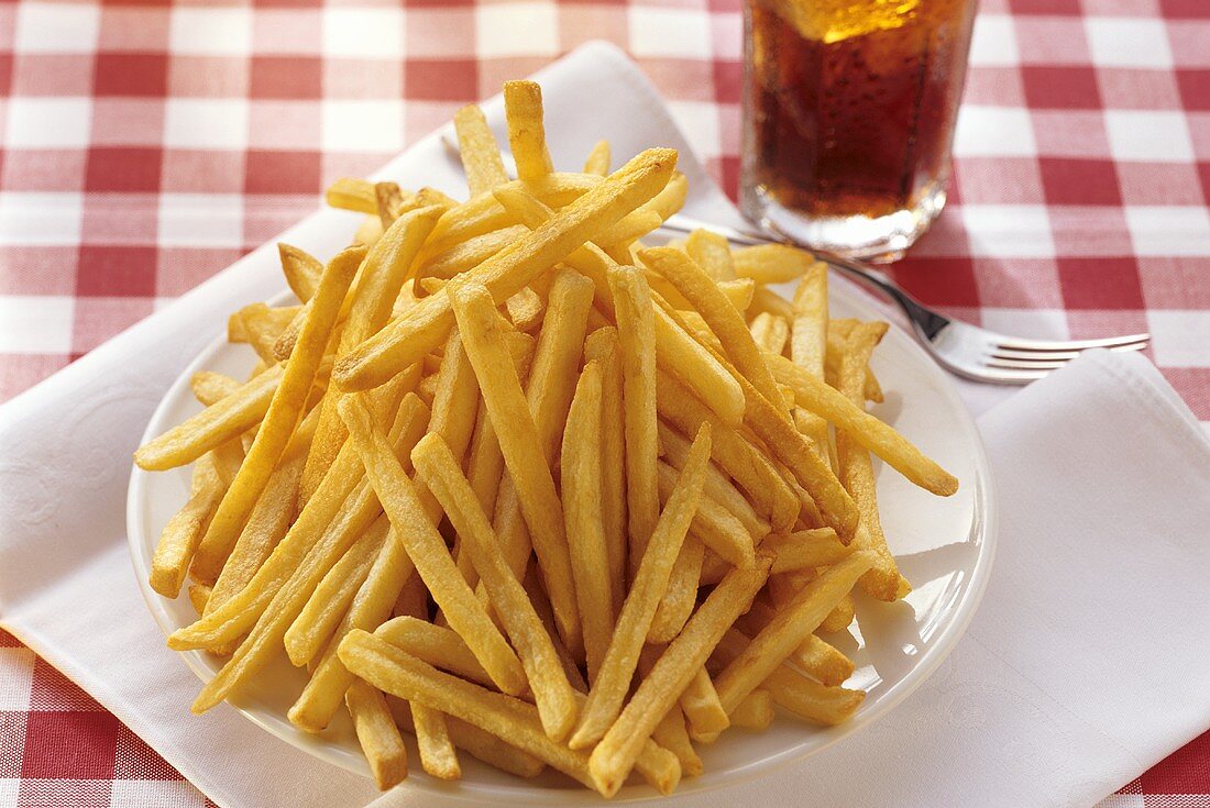 A large plate of chips, fork and Coca Cola