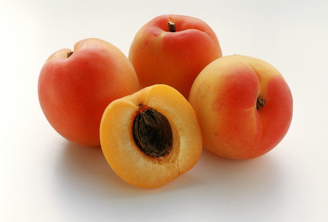 Aprikosen, eine davon halbiert mit Kern