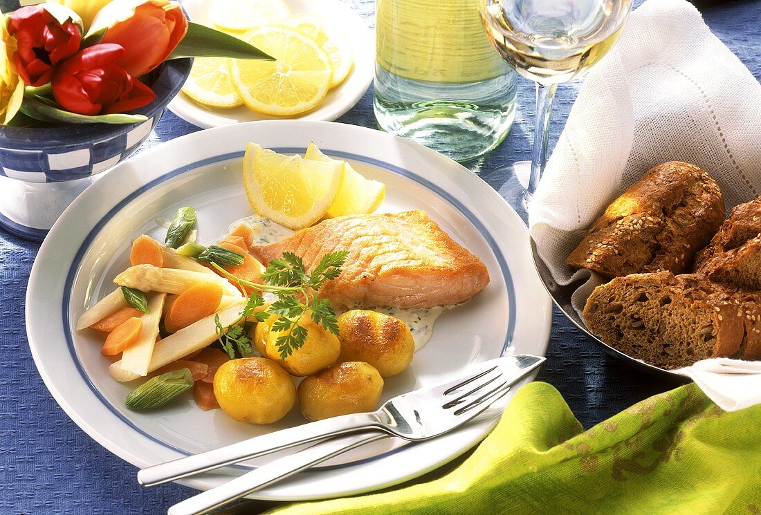 Salmon with fried potatoes, vegetables & lemon wedges; bread