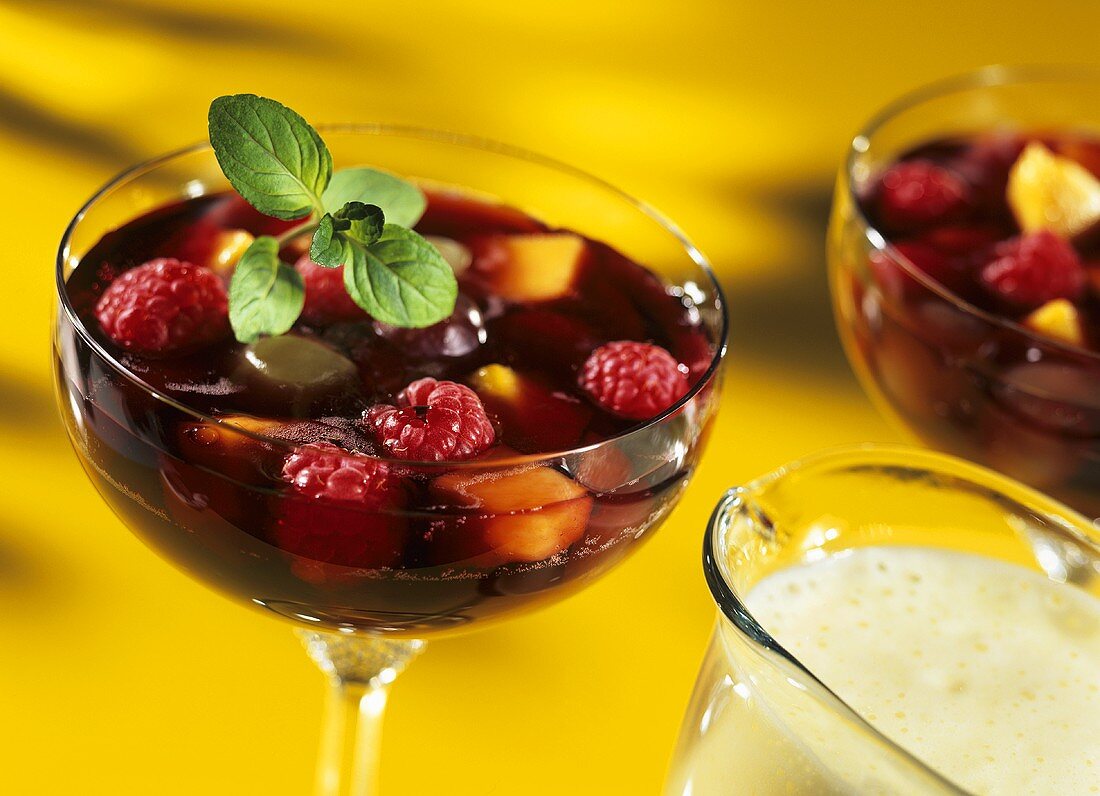Colourful fruit jelly with berries; frothy champagne sauce 