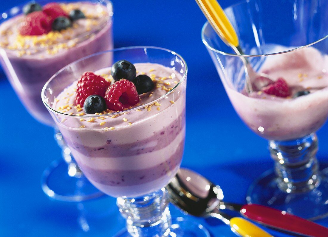 Coloured quark layers with fresh berries & sesame in glasses