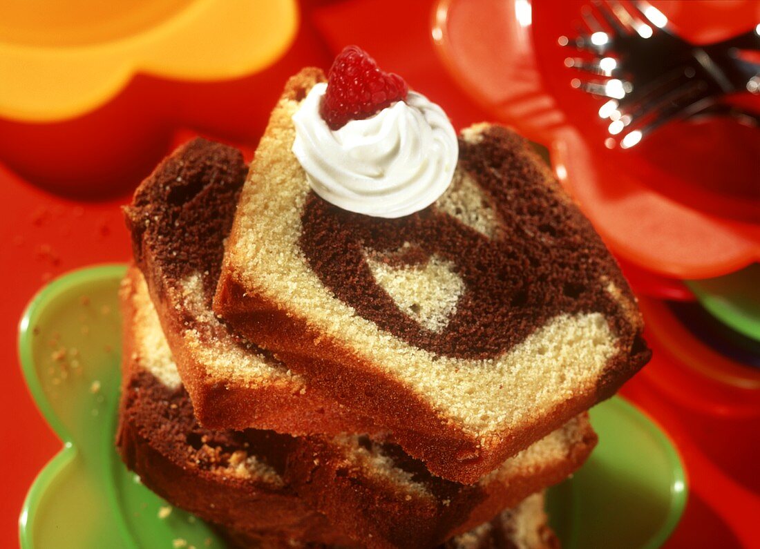 Pieces of marble cake with cream and fresh raspberry