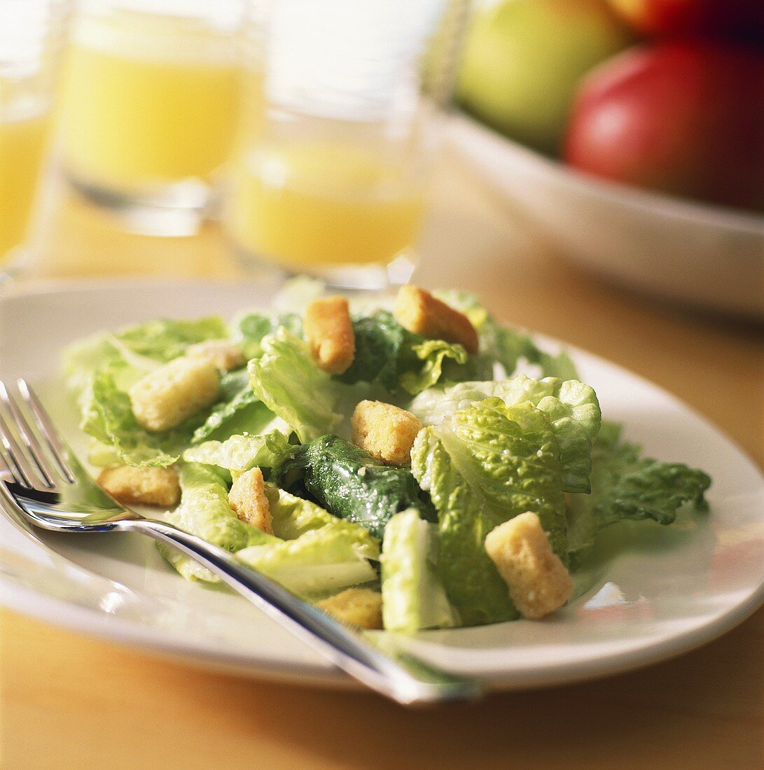 Cäsarsalat mit Croûtons auf Teller mit Gabel