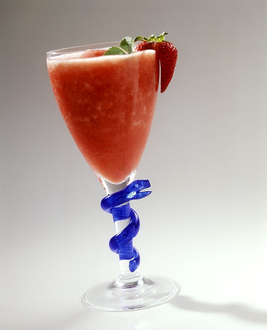 Strawberry daiquiri in a glass with plastic snake