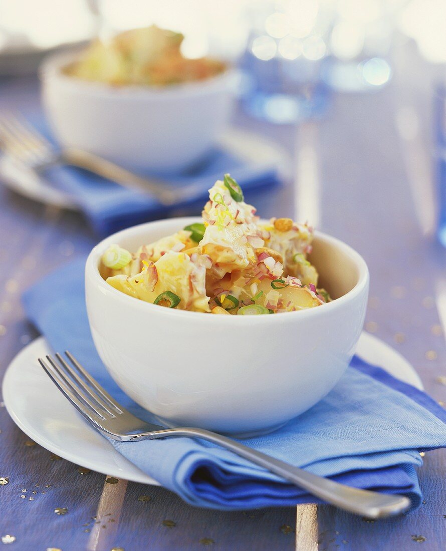 Kartoffelsalat mit Zwiebeln in weissen Schalen