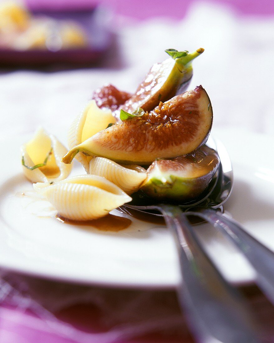 Pasta shells with figs on a plate with cutlery