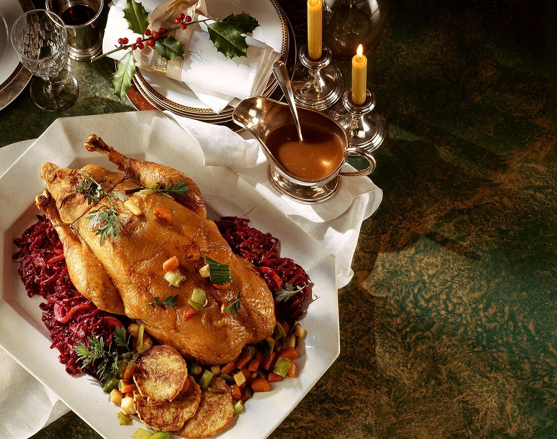 Whole stuffed duck with red cabbage; candles; Christmas décor