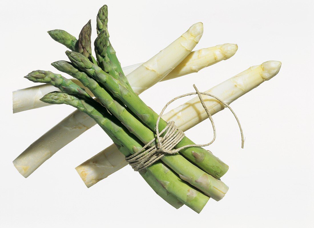 A bundle of green asparagus & three stalks of white asparagus