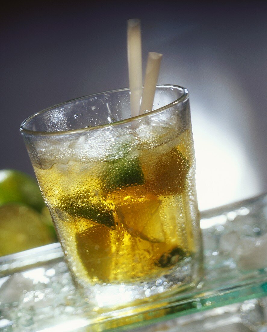 Caipirinha cocktail with limes and ice cubes