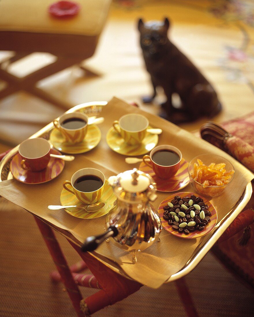 Coffee on a tray with pralines and candied oranges