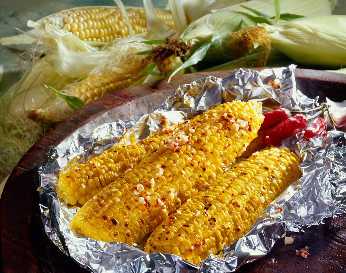 Corn cobs with chili and garlic in aluminium foil