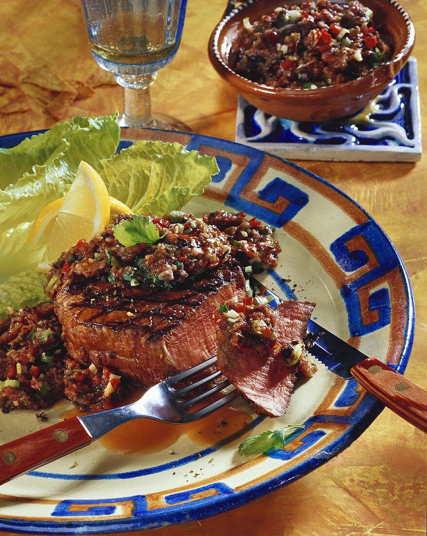 Tequila steaks with bean salsa on plate