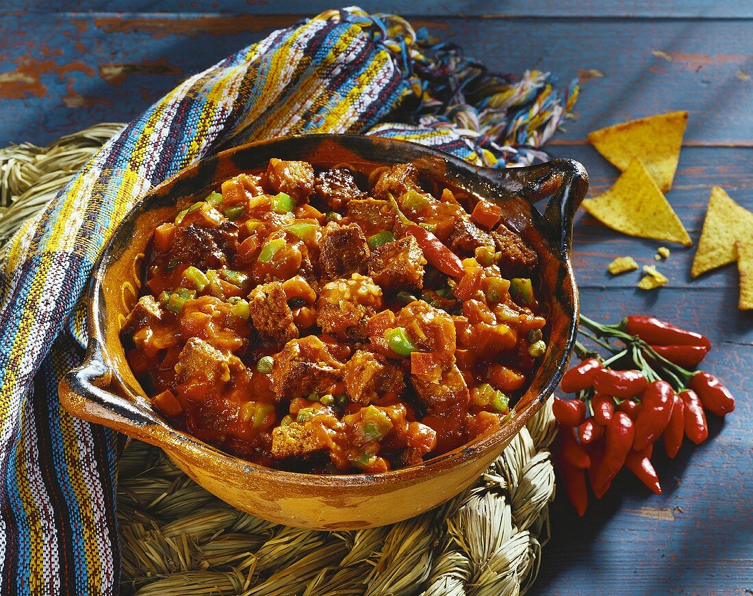 Fiery chili with capers in ceramic pot