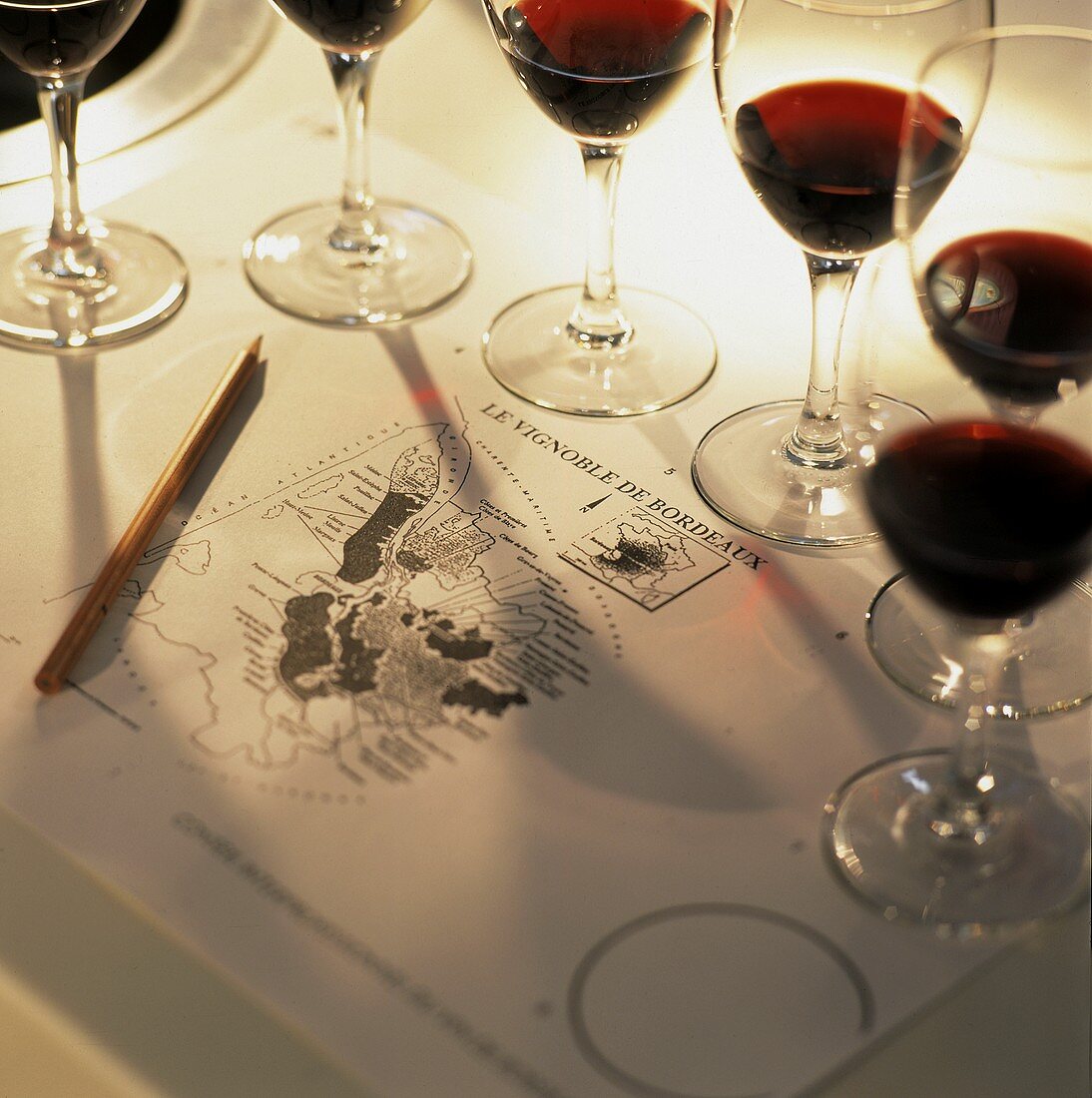 Half filled Bordeaux glasses around a map of Bordeaux