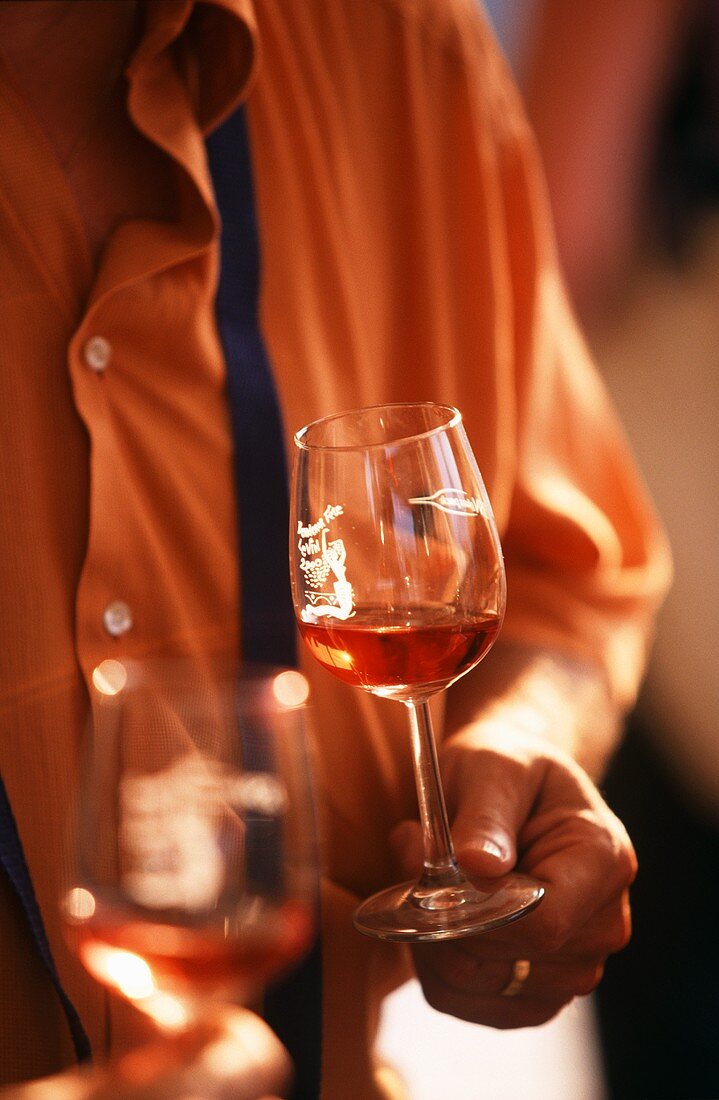 Person holding two glasses of red wine