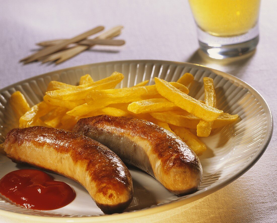 Fried sausages with chips and ketchup on a plate