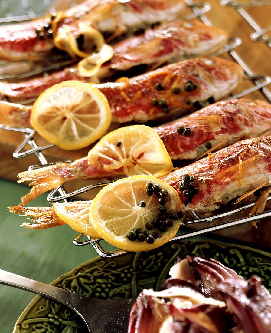 Red mullet with lemon slices on the grill
