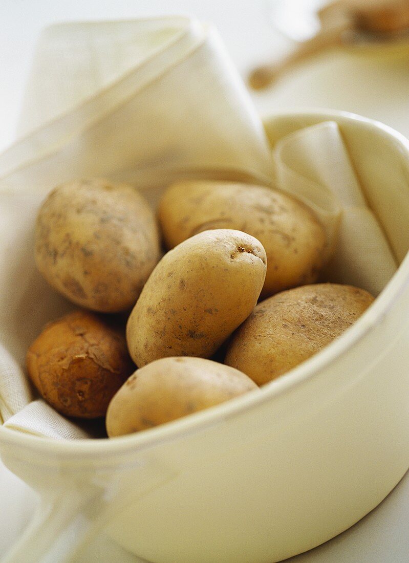Kartoffeln mit Tuch in weisser Schüssel
