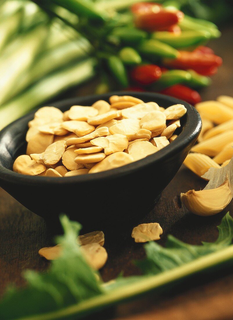 Dried beans in a bowl; chili peppers; garlic