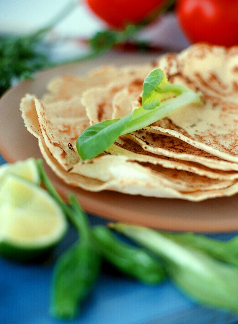 Tortillas auf einem Stapel, Tomaten und Limetten