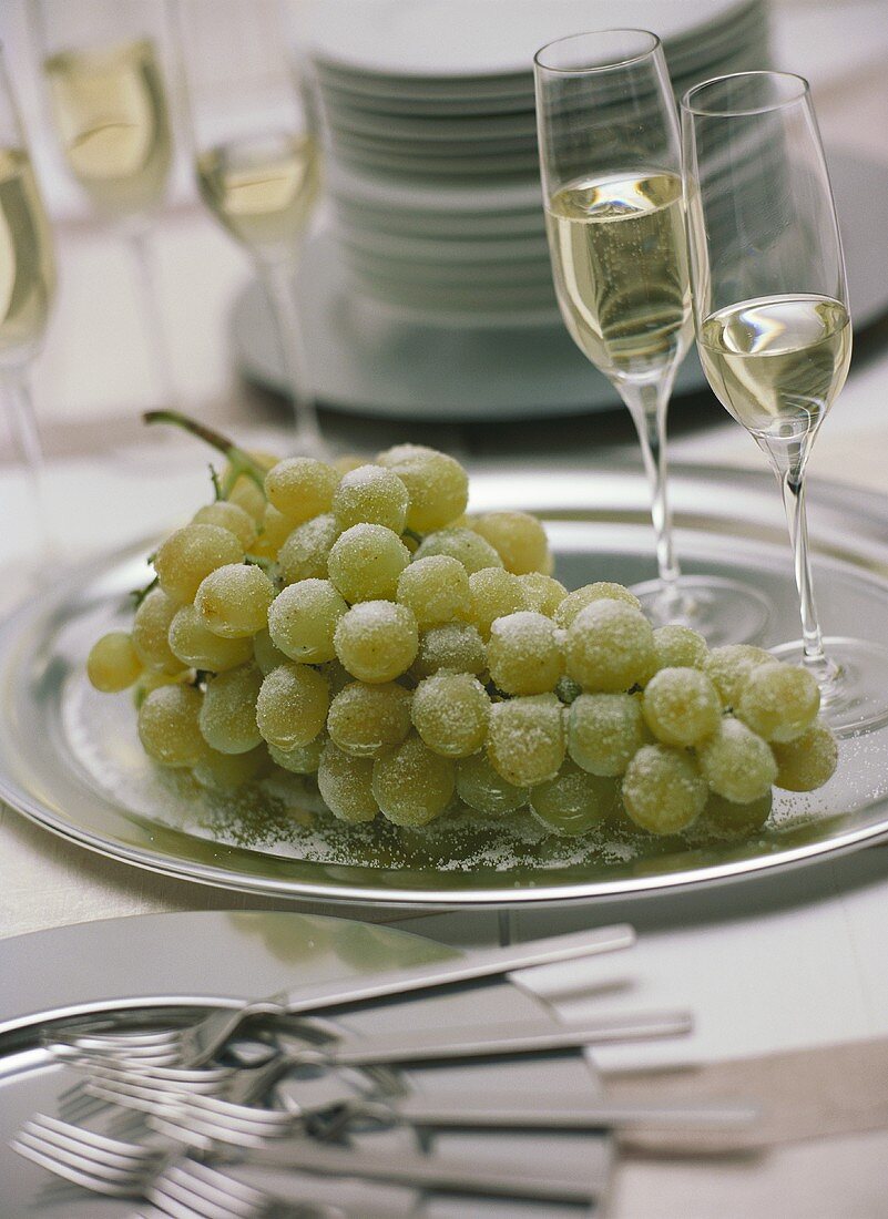 Champagne glasses with sugared green grapes on silver plate