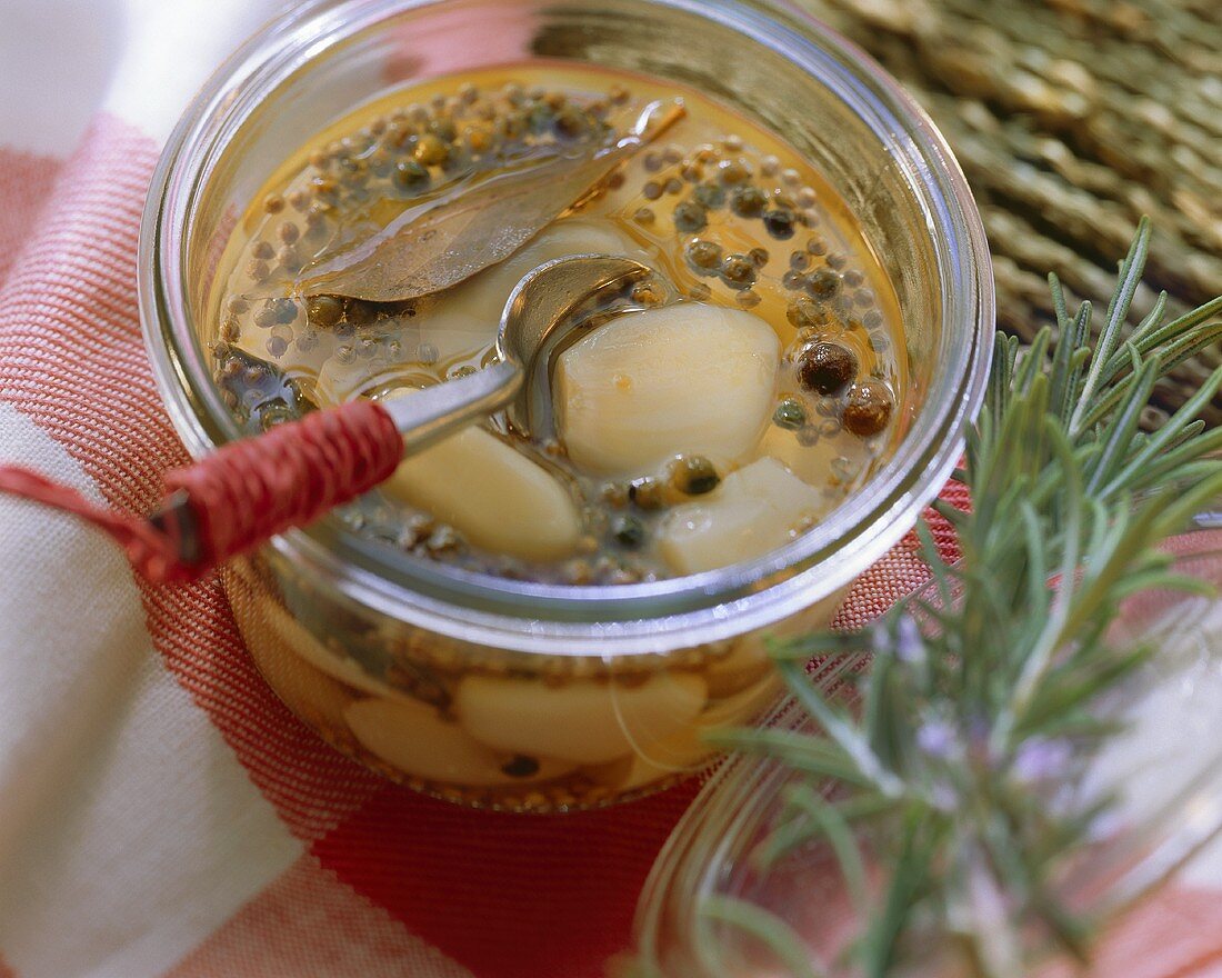 Spicy pickled garlic with bay in a preserving jar