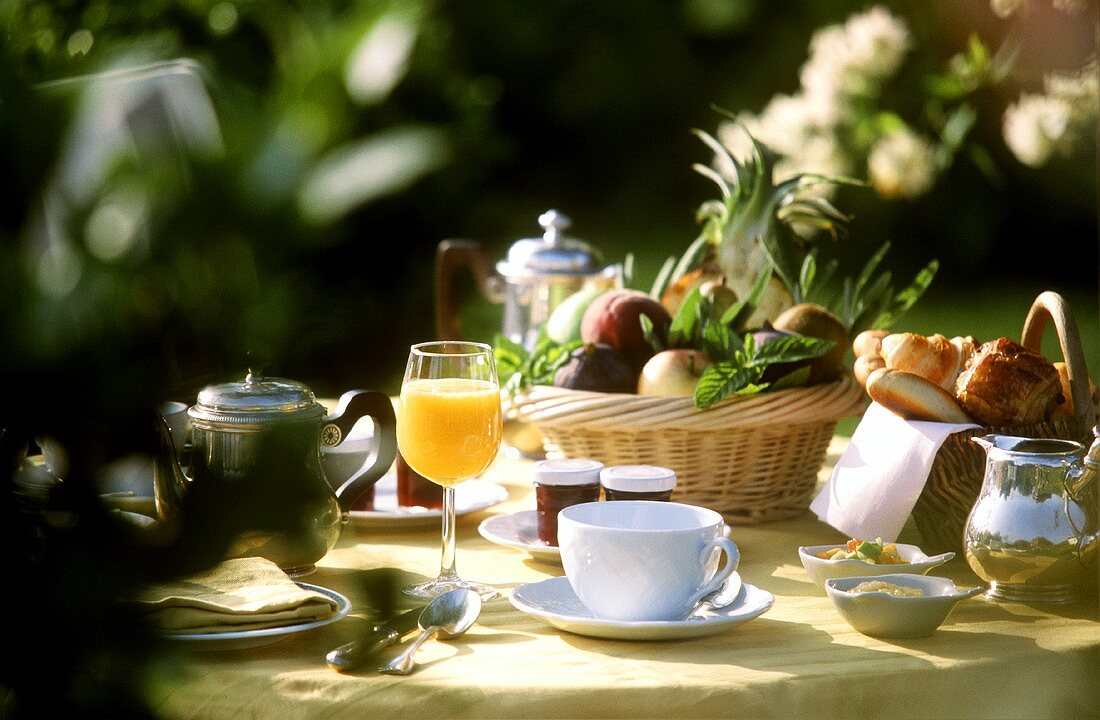 Gedeckter Frühstückstisch mit Obst, Orangensaft, Kaffee