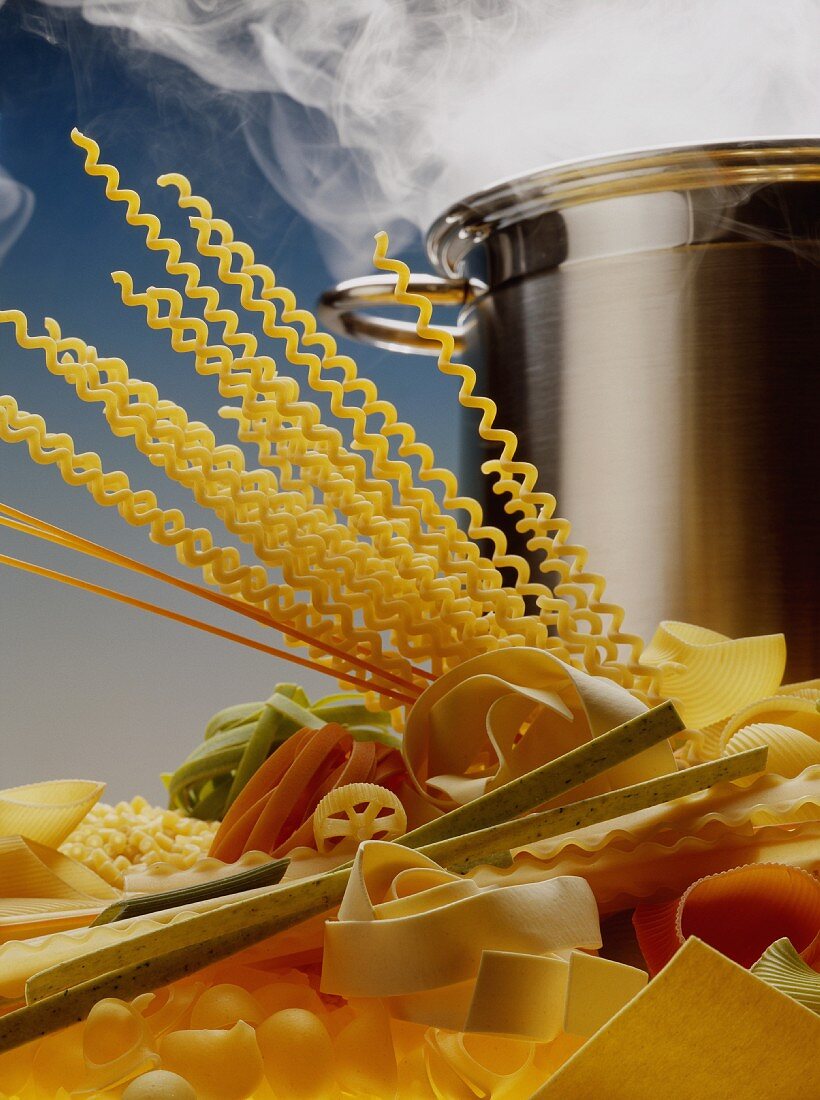Various pastas in front of a steaming pan