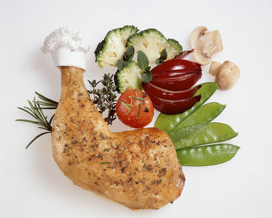 Chicken leg and vegetables on a white background