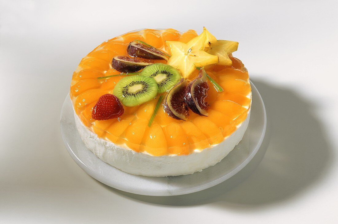 Pfirsich-Sahne-Torte mit exotischen Früchten auf Marmorteller