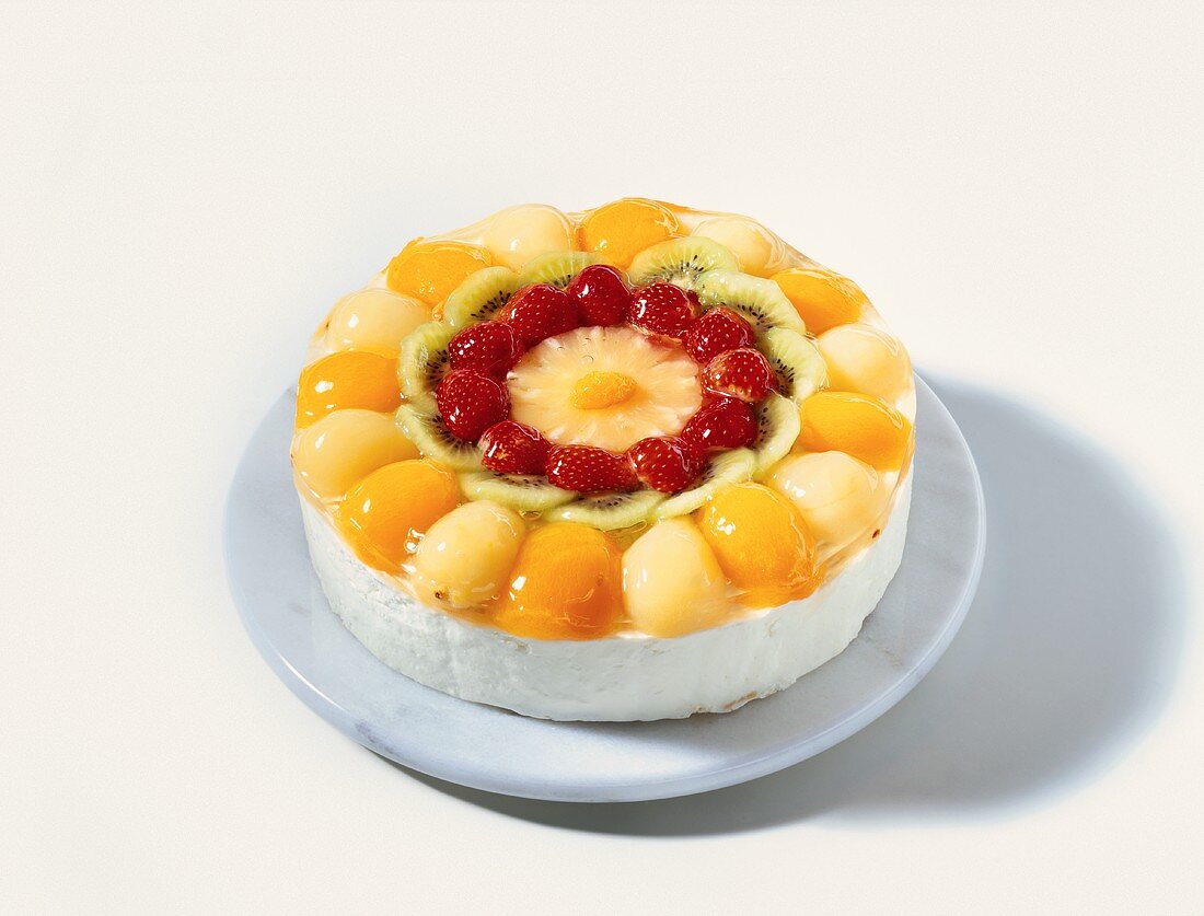 Cream gateau with fruit on marble plate