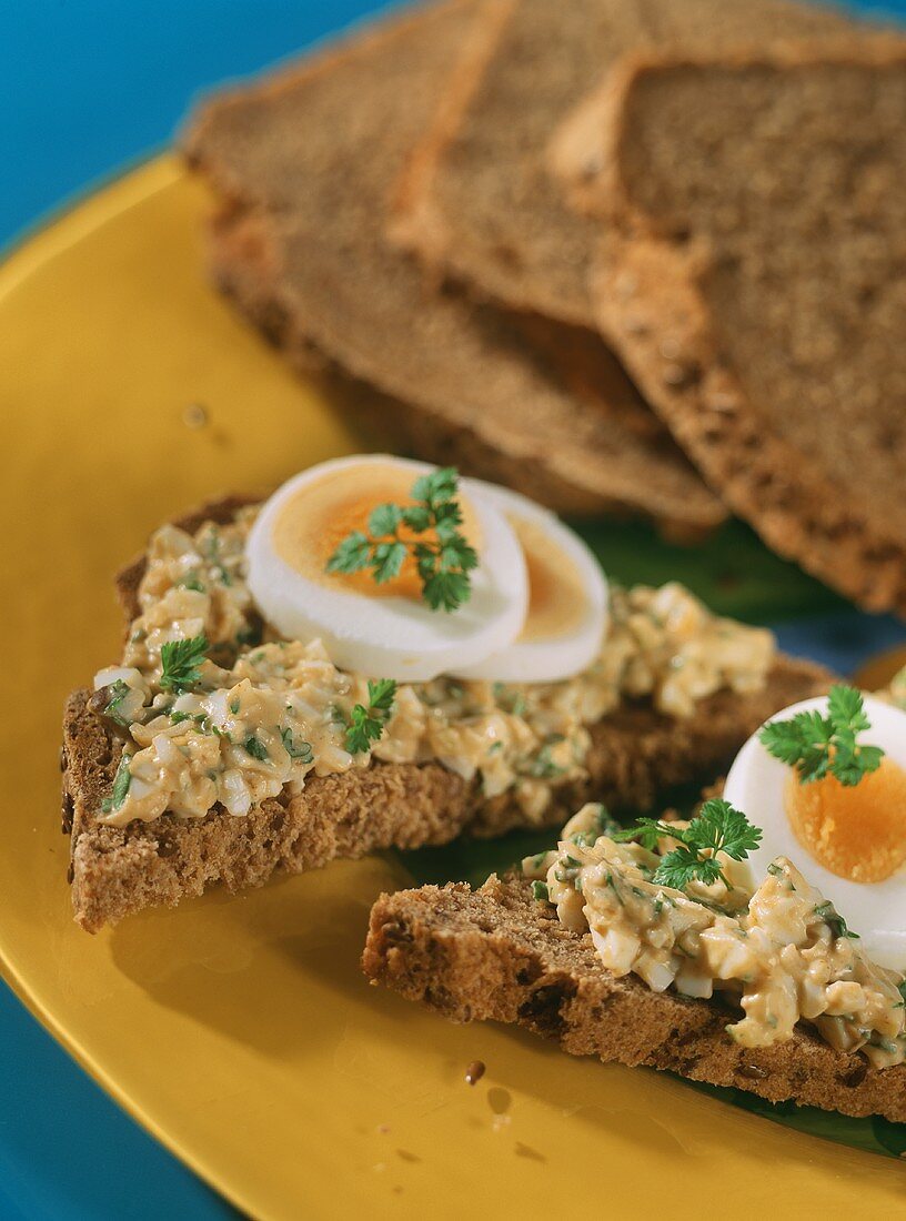 Linseed bread with egg spread on yellow plate