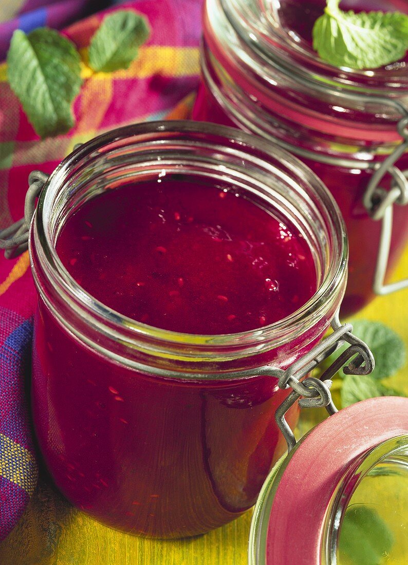 Raspberry and blackberry jam in jam jars; mint
