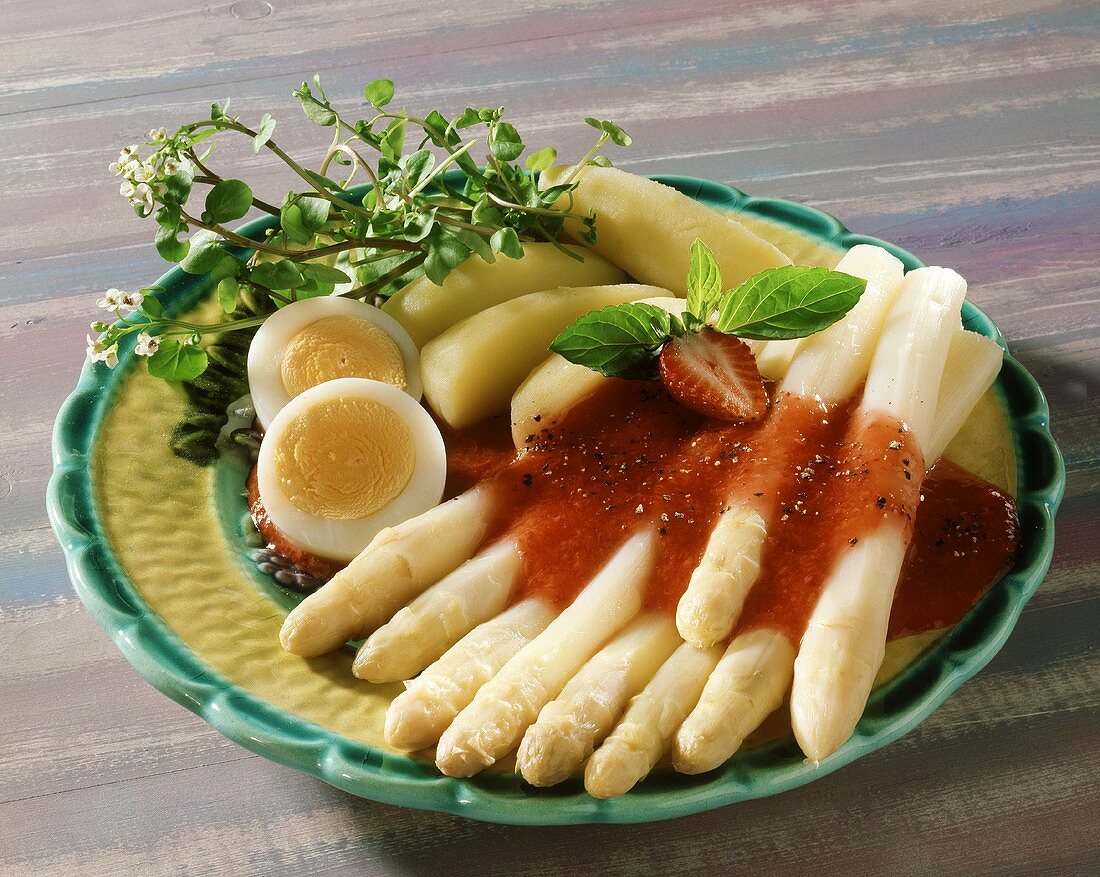 White asparagus with strawberry sauce, boiled potatoes and egg