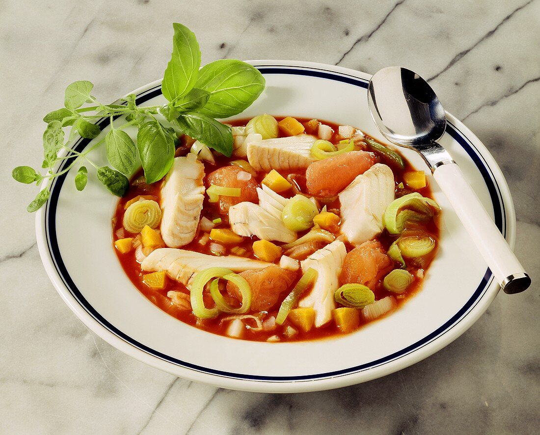 Fish stew with tomatoes and leeks on plate