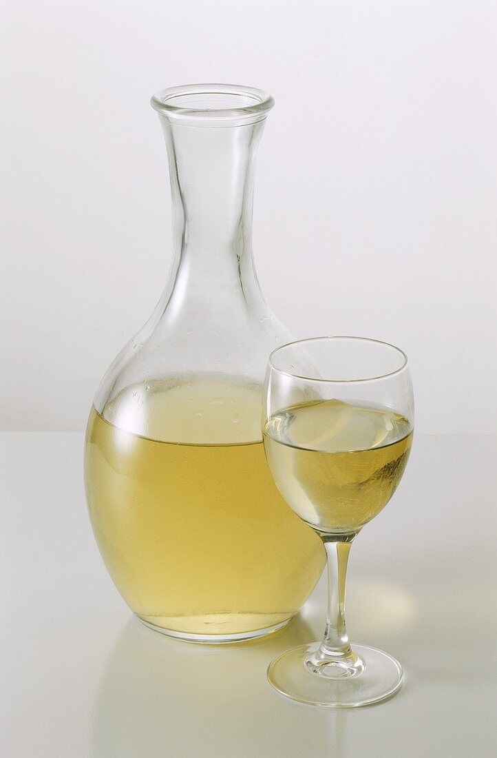 Weißwein in Glas und Karaffe