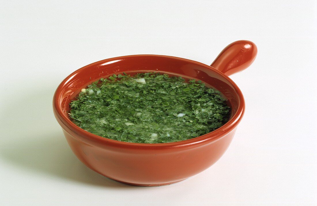 Herb sauce in a red china dish