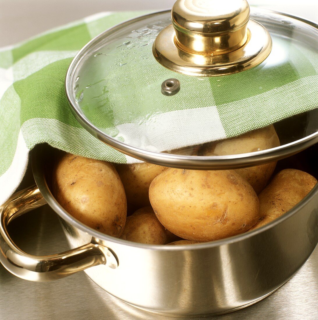 Potatoes in stainless steel pan with glass lid & fabric napkin
