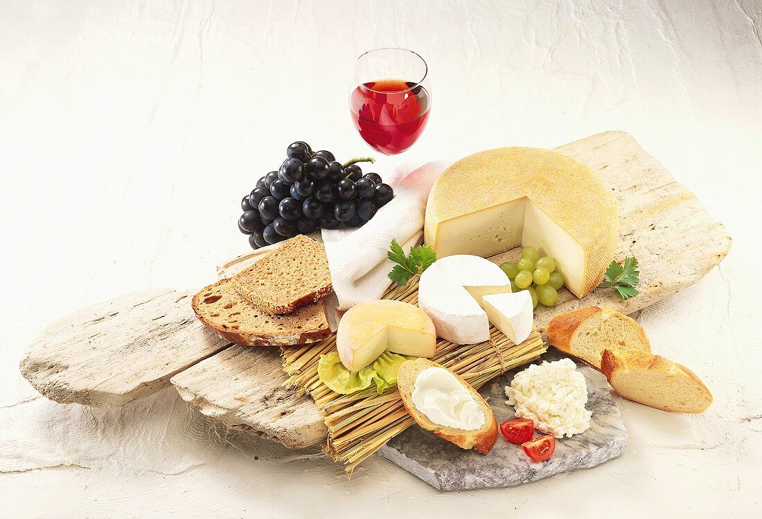Various types of cheese with bread, grapes & red wine