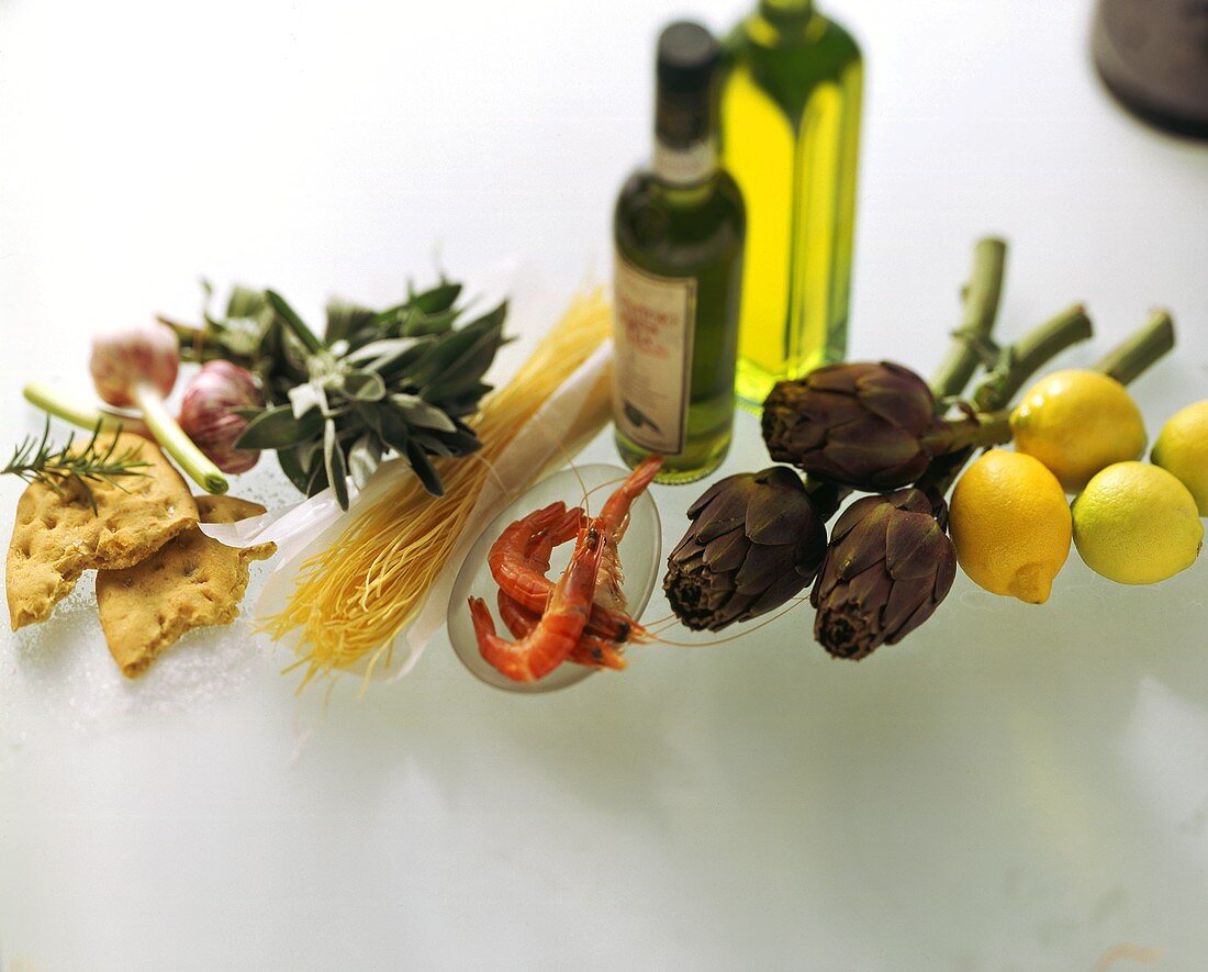Still life with olive oil, vegetables, shrimps, lemons, noodles