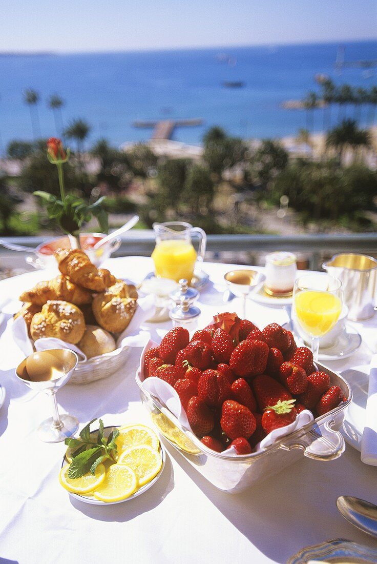 Urlaubsfrühstück mit frischen Erdbeeren auf Terrasse am Meer