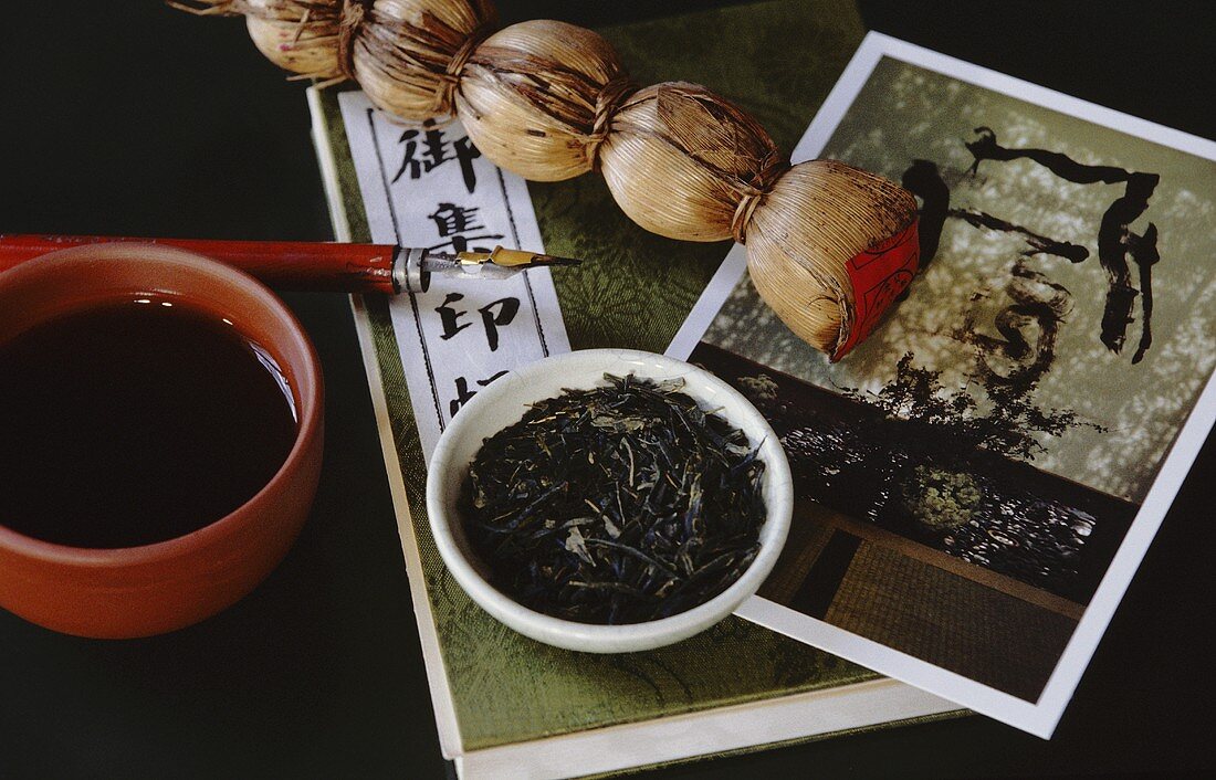 Asian tea scene with tea bowl, tea pearls, tea leaves etc.