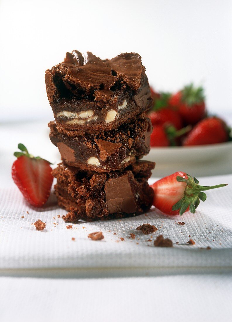 Pile of brownies with strawberries on white cloth