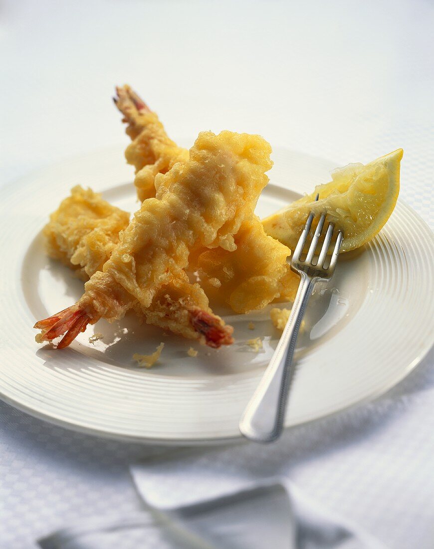 Fried shrimps with lemon wedge on plate
