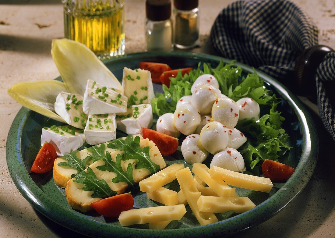 Käseplatte mit Tomaten, Salat und Schnittlauch