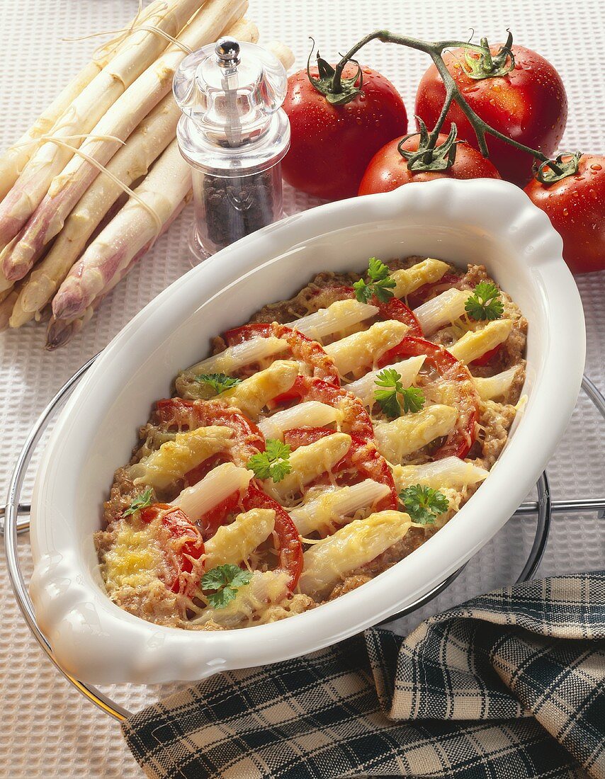 Asparagus gratin with tomatoes in the baking dish